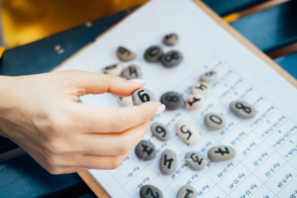 Woman numerologist hand with pebble stone with number nine 9